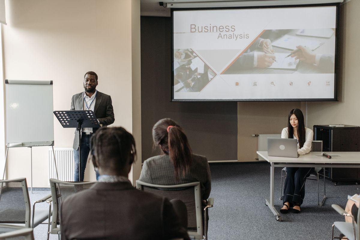 A speaker leading a business analysis seminar with an engaged audience